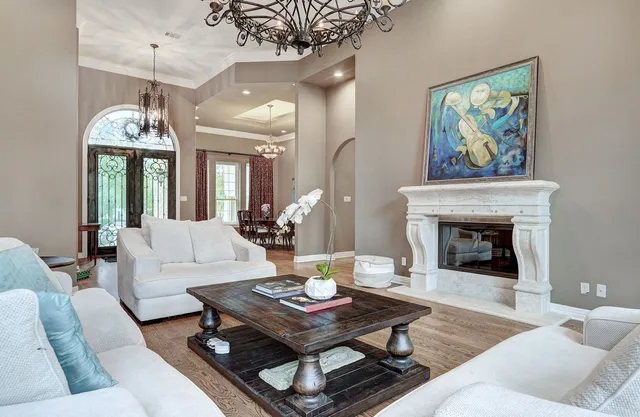 a living room with furniture a fireplace and a chandelier