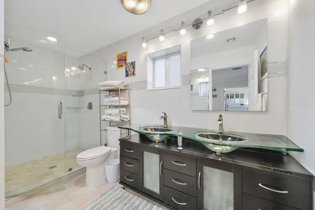 a bathroom with a sink a toilet and shower