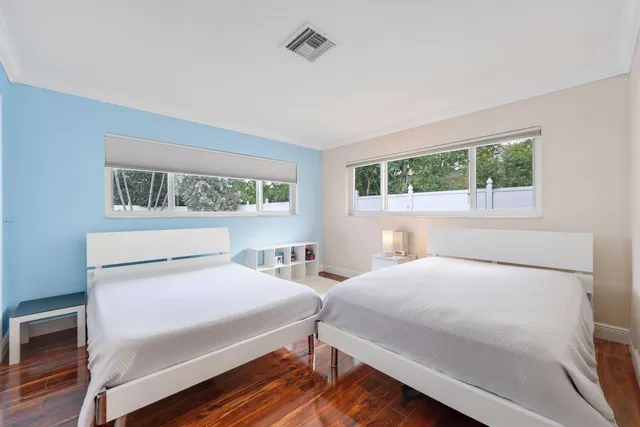 a bedroom with two beds and a window