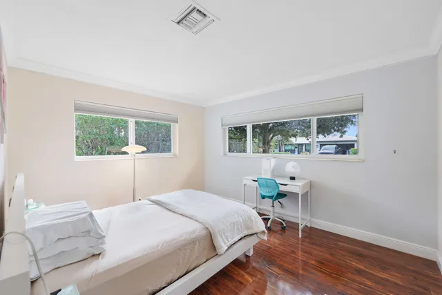 a bedroom with a bed table and a window