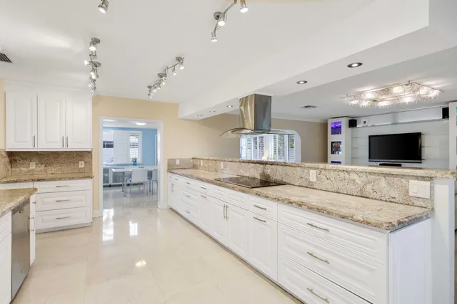 a large kitchen with kitchen island a sink stainless steel appliances and cabinets