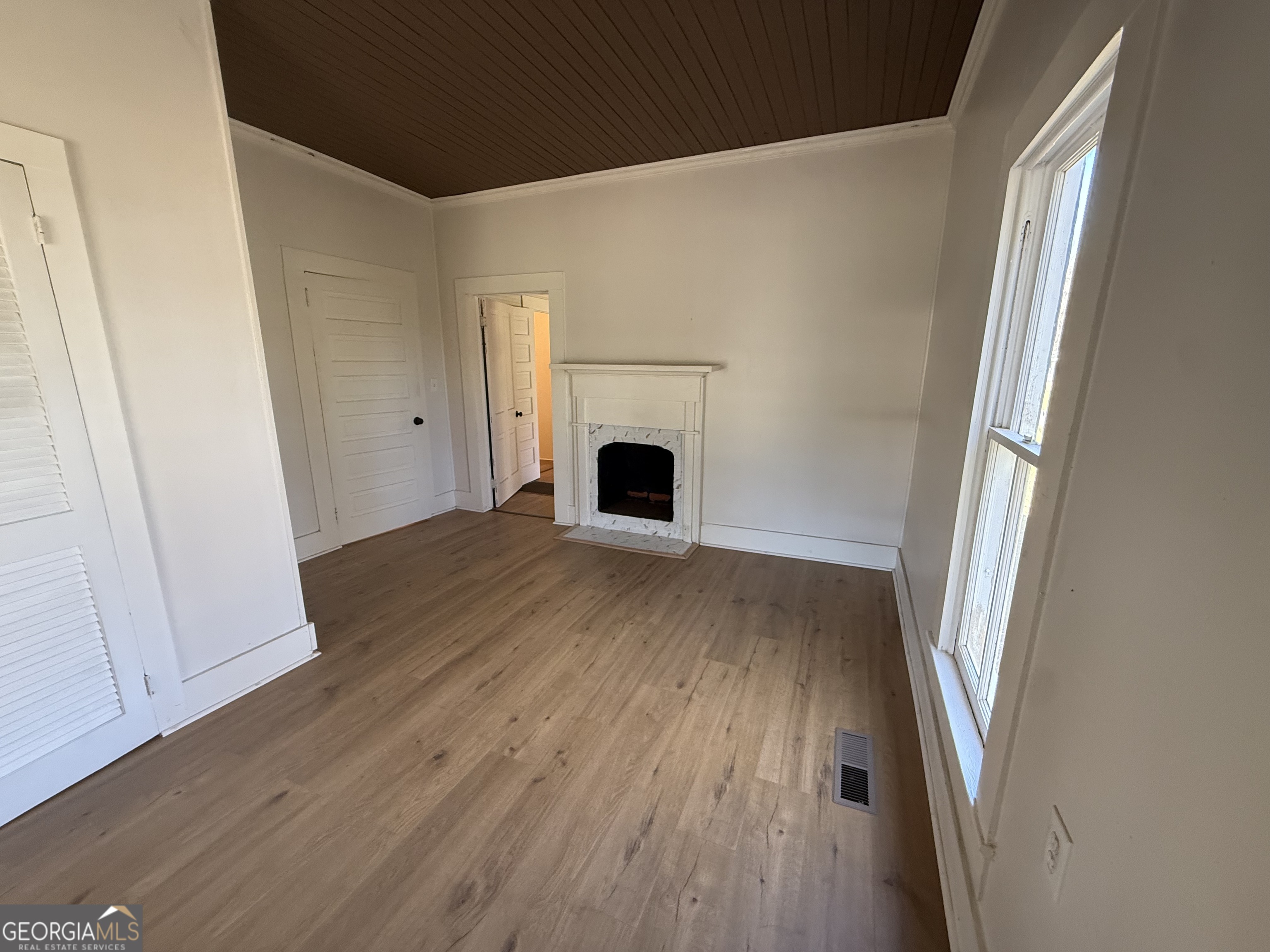 604 Shy Street Dexter, GA 31019 - Photo 24 of 36 an empty room with wooden floor and fireplace