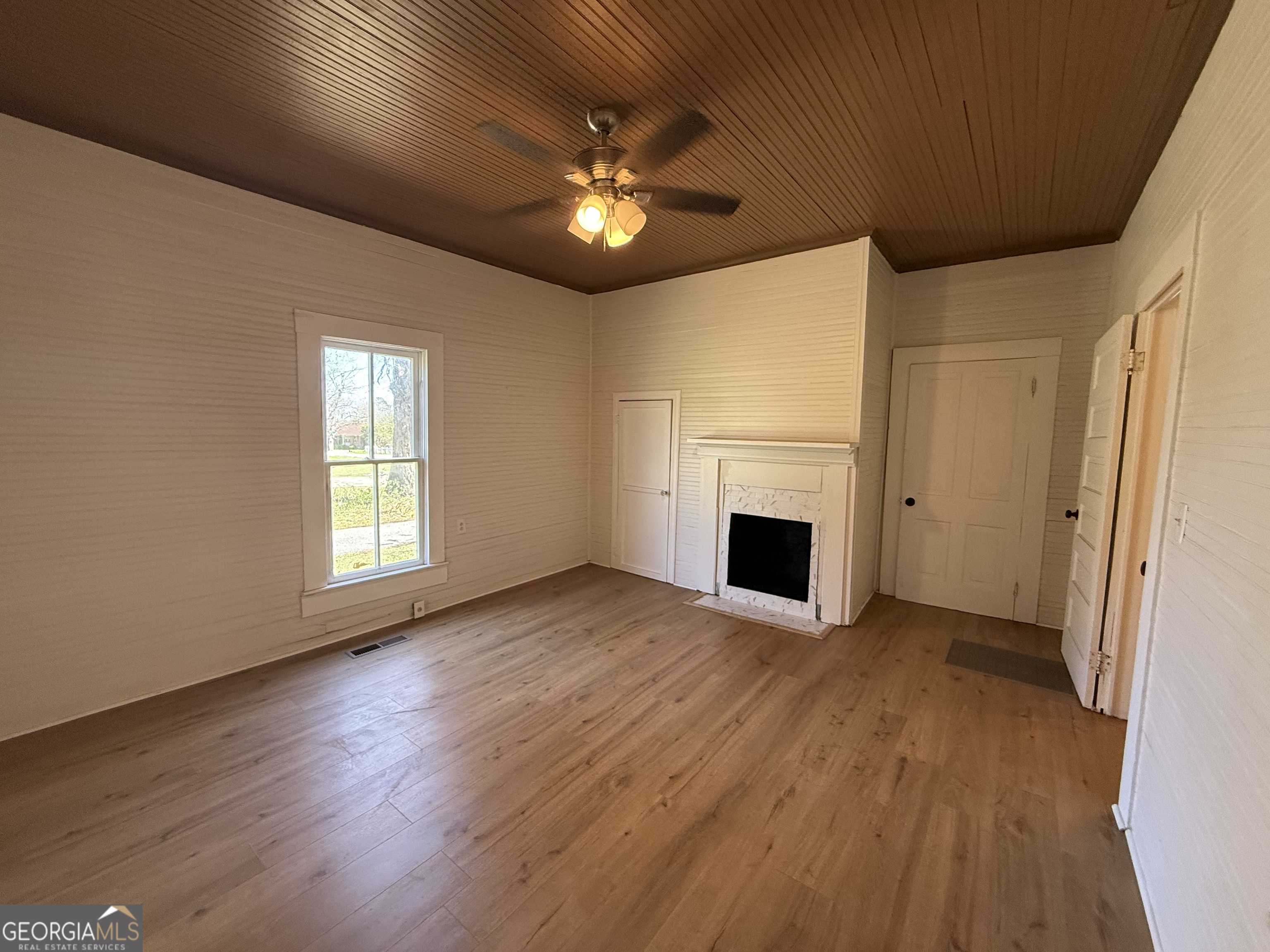 604 Shy Street Dexter, GA 31019 - Photo 27 of 36 a view of a livingroom with a fireplace a chandelier and wooden floor