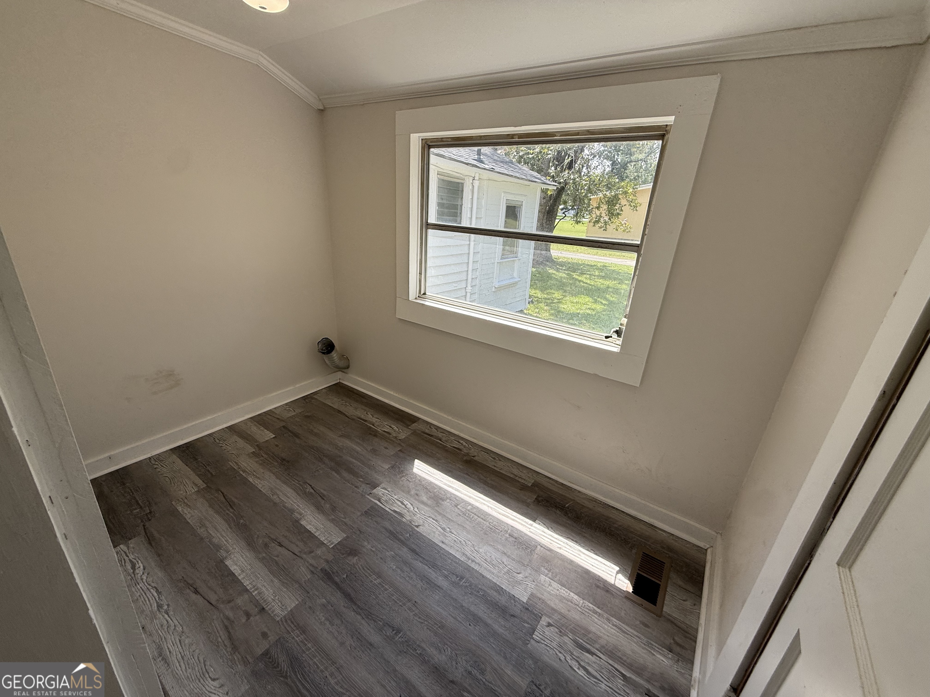 604 Shy Street Dexter, GA 31019 - Photo 31 of 36 a view of an empty room with wooden floor and a window
