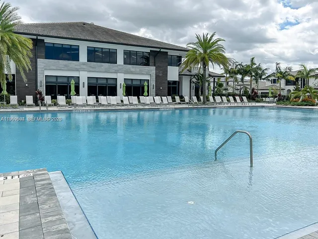 a house view with swimming pool and sitting space