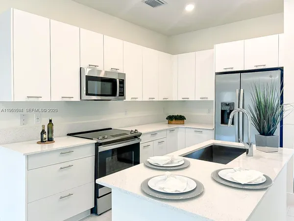 a kitchen with appliances a sink and cabinets
