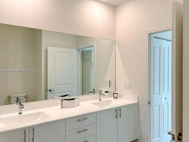 a bathroom with 2 sink and a mirror