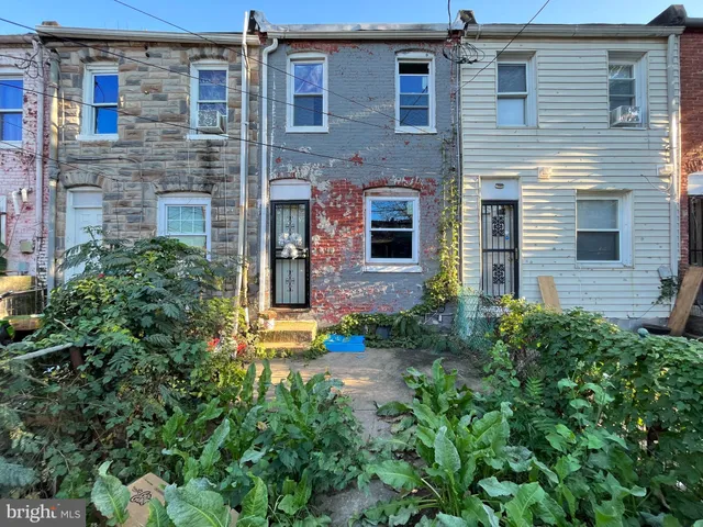 a view of a brick house with many windows and plants