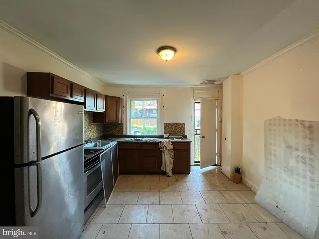 a kitchen with stainless steel appliances granite countertop a refrigerator sink and stove