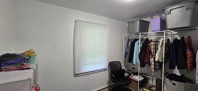 a view of walk in closet with clothes and shoes