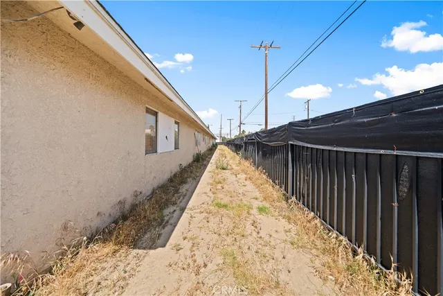 a view of an empty room with wooden floor and windows