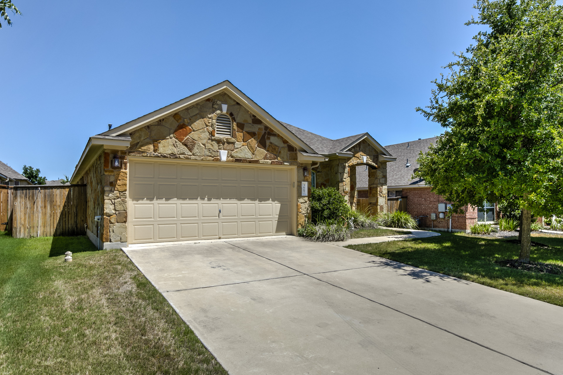 3667 Rosalina Loop Round Rock, TX 78665 - Photo 1 of 26 View of front facade with stone siding, concrete driveway, and an attached garage