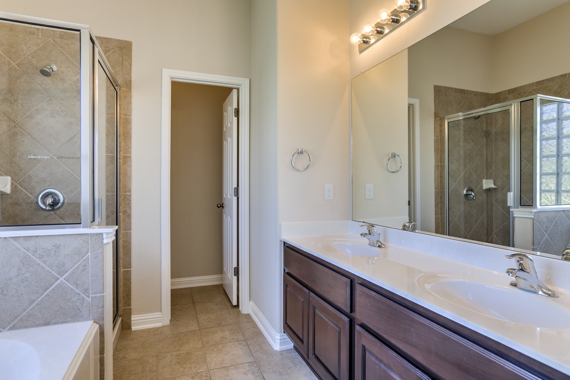 3667 Rosalina Loop Round Rock, TX 78665 - Photo 16 of 26 Bathroom featuring a stall shower, double vanity, a bath, and light tile patterned floors
