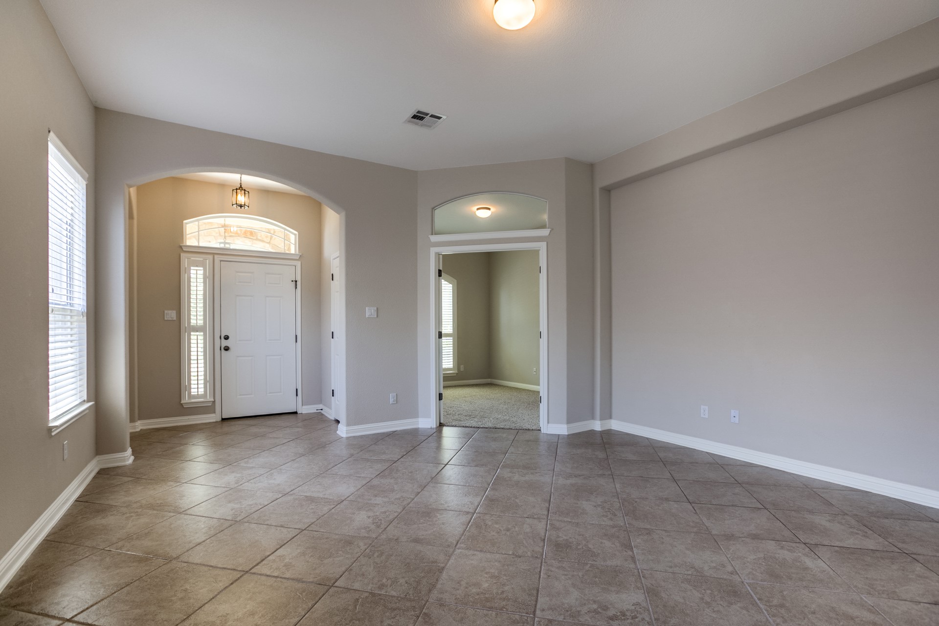 3667 Rosalina Loop Round Rock, TX 78665 - Photo 4 of 26 Foyer with arched walkways, healthy amount of natural light, and light tile patterned flooring