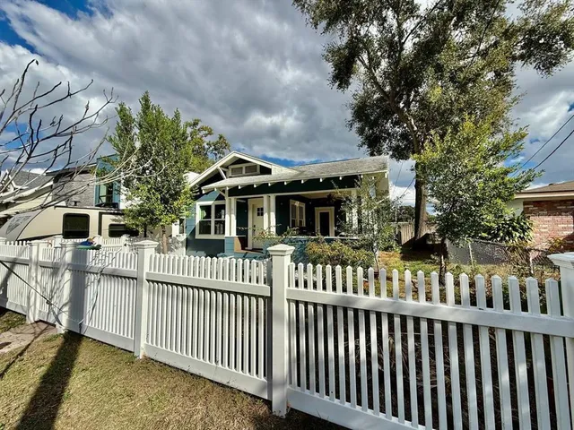 a view of a house with a small yard and wooden fence