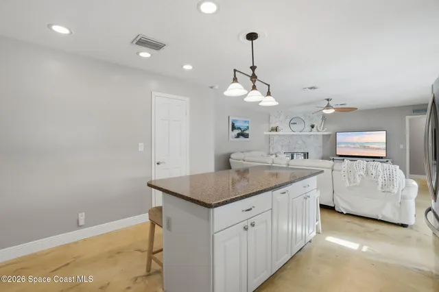 a living room with furniture ceiling fan and a flat screen tv