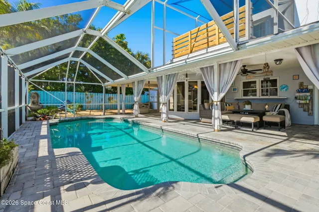 a view of a patio with table and chairs potted plants and palm trees