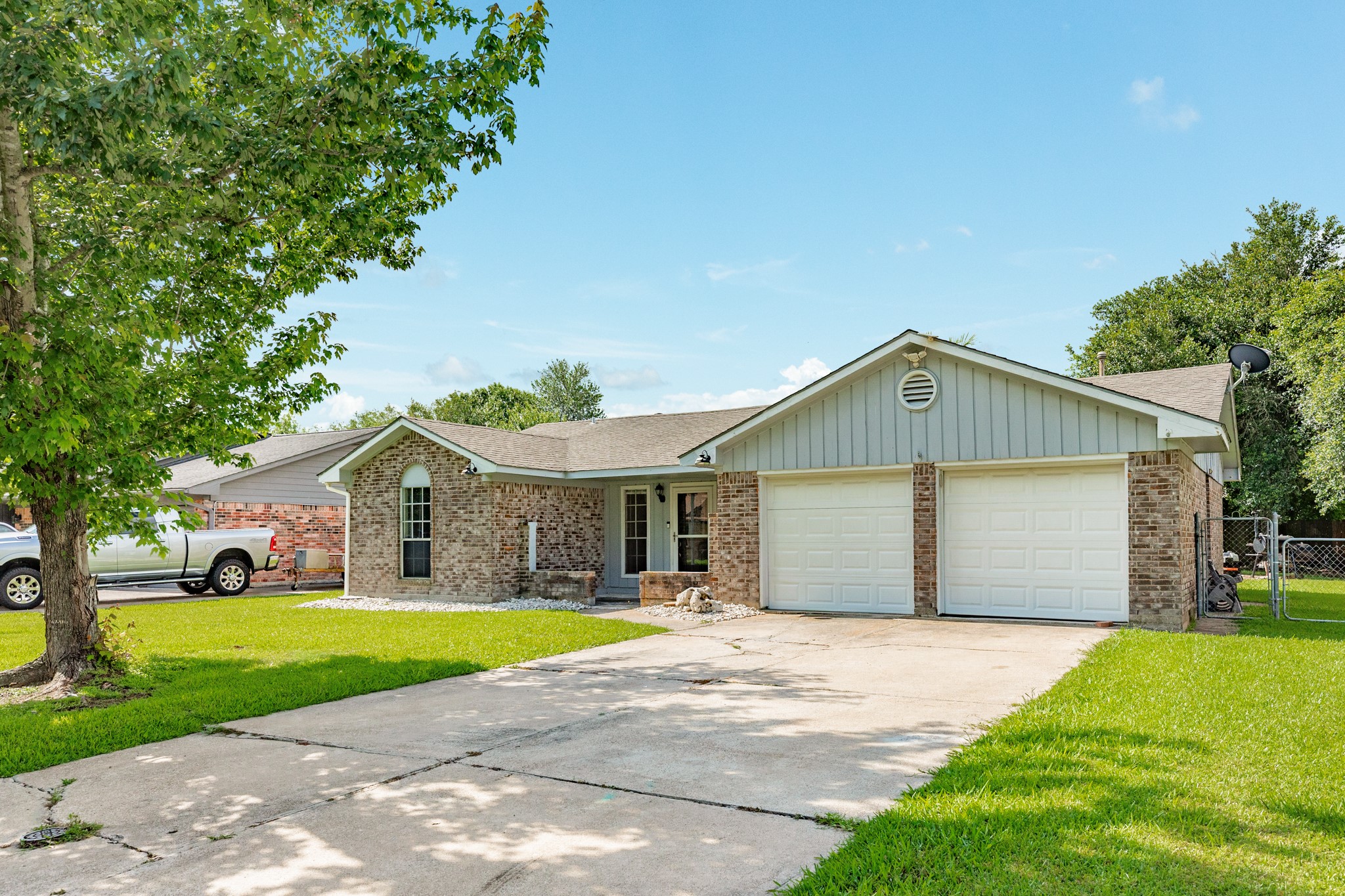128 Houston Street Angleton, TX 77515 - Photo 4 of 25 a front view of a house with a yard and garage