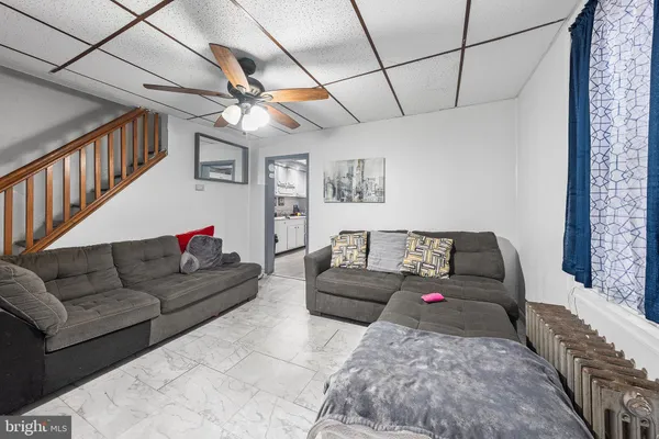 a living room with furniture and a ceiling fan
