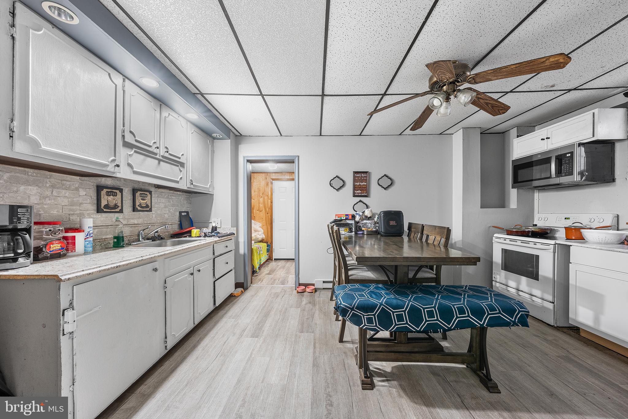 707 East 5th Street Bethlehem, PA 18015 - Photo 7 of 22 a kitchen with stainless steel appliances granite countertop a stove top oven a sink dishwasher a dining table and chairs with wooden floor