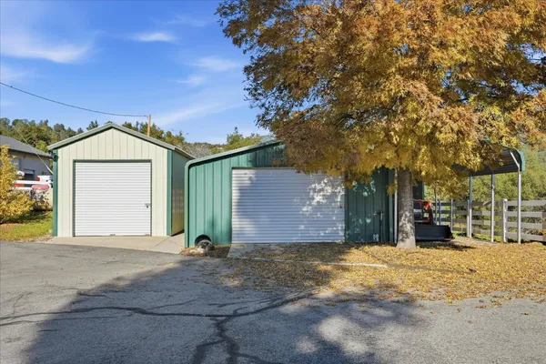 a view of a big house with a big yard and large tree