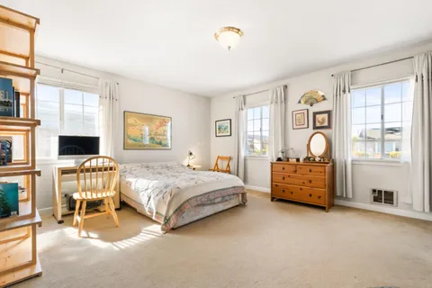 a bedroom with a bed and a large window