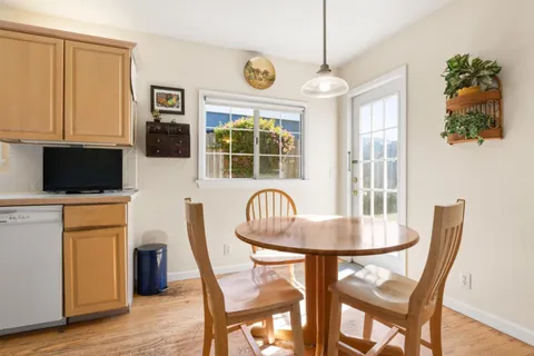 a dining room with furniture a window and wooden floor