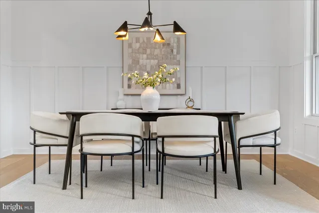 a kitchen with stainless steel appliances a dining table chairs and a refrigerator