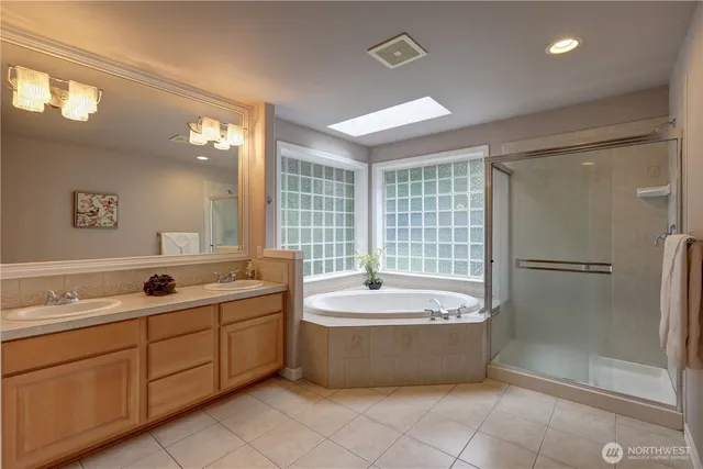 a spacious bathroom with a tub sink shower and mirror