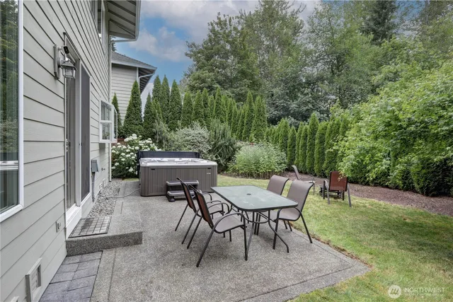 a view of a patio with table and chairs and potted plants with wooden floor and fence