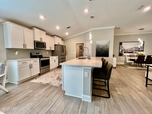 a kitchen with granite countertop white cabinets and stainless steel appliances