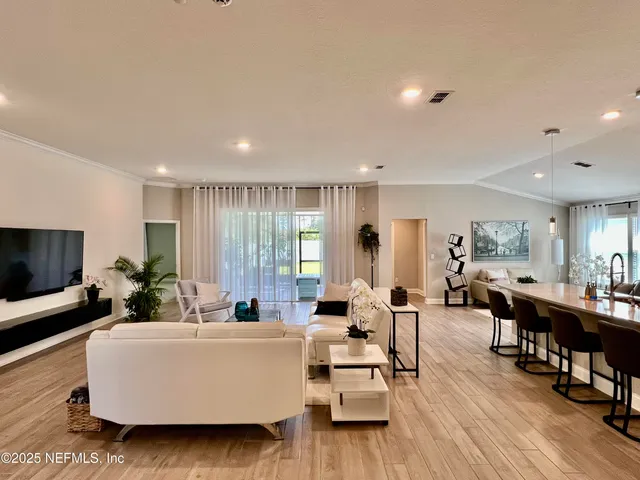 a living room with furniture and a dining table with kitchen view