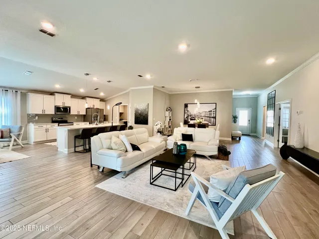 a living room with furniture a flat screen tv and a potted plant