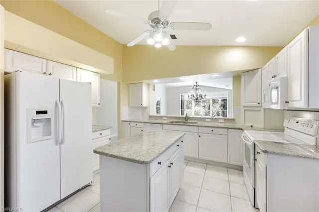 a kitchen with granite countertop a sink cabinets stainless steel appliances and a island