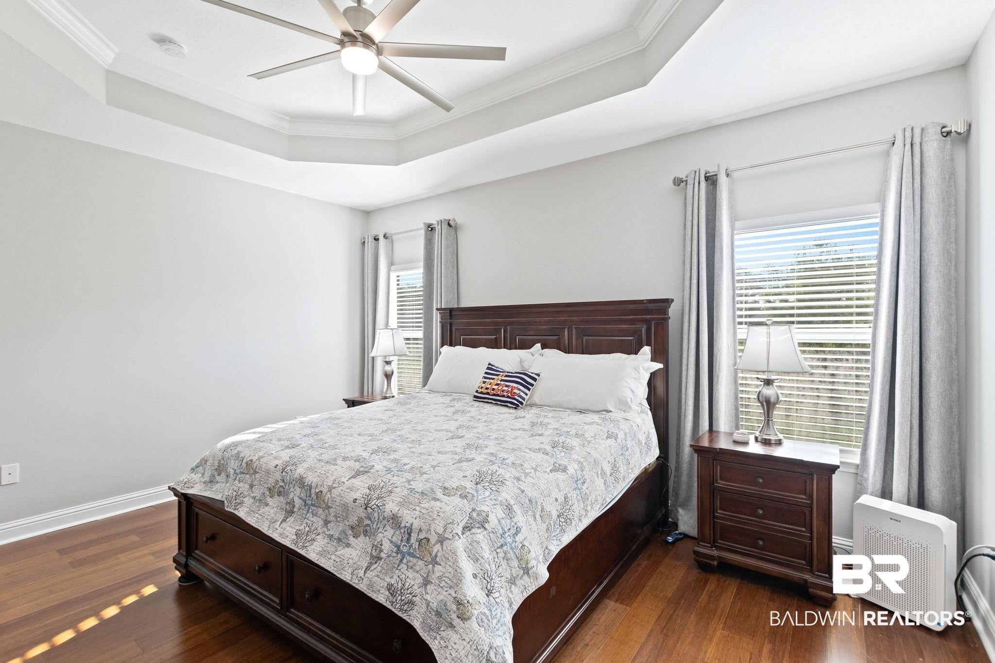 31541 Hoot Owl Road Daphne, AL 36527 - Photo 23 of 51 Bedroom with crown molding, dark hardwood / wood-style floors, ceiling fan, and a raised ceiling