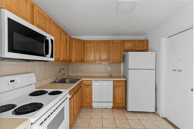a kitchen with stainless steel appliances granite countertop white cabinets a stove a sink and dishwasher