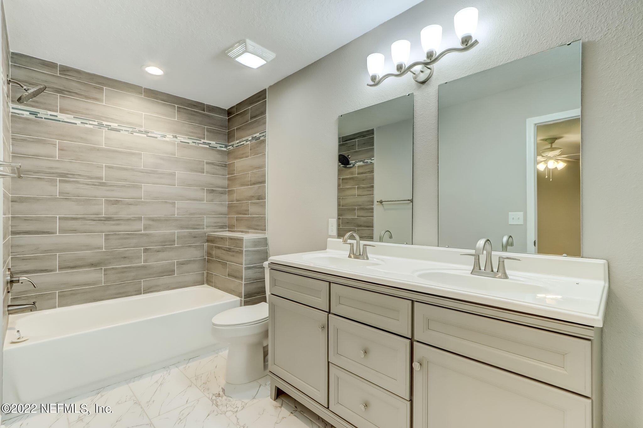 5218 Sunderland Road Jacksonville, FL 32210 - Photo 11 of 23 a bathroom with a double vanity sink toilet mirror and bathtub