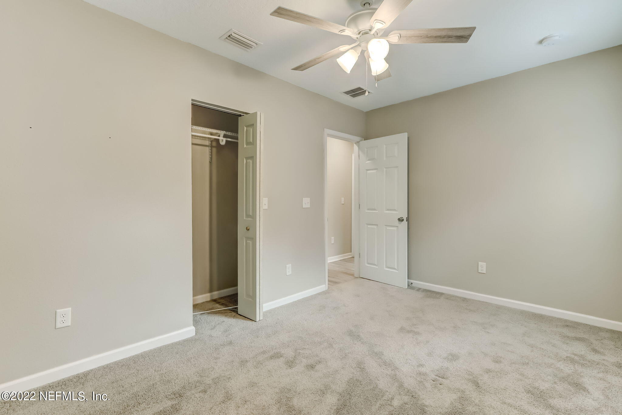 5218 Sunderland Road Jacksonville, FL 32210 - Photo 16 of 23 an empty room with a chandelier fan and windows