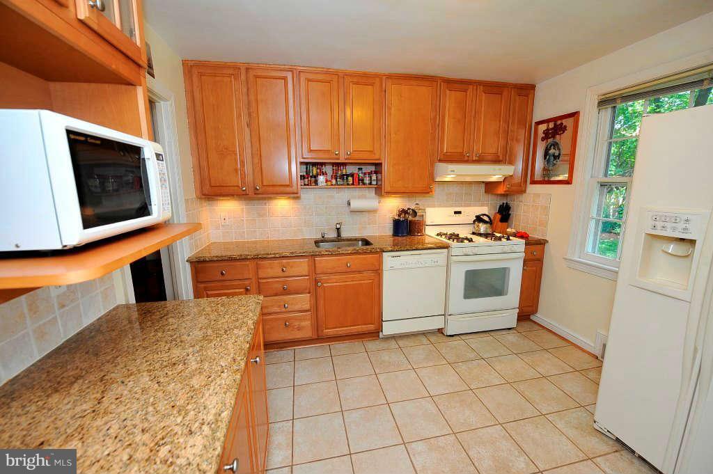 4523 Sleaford Road Bethesda, MD 20814 - Photo 3 of 23 a kitchen with stainless steel appliances a stove a sink a microwave and cabinets