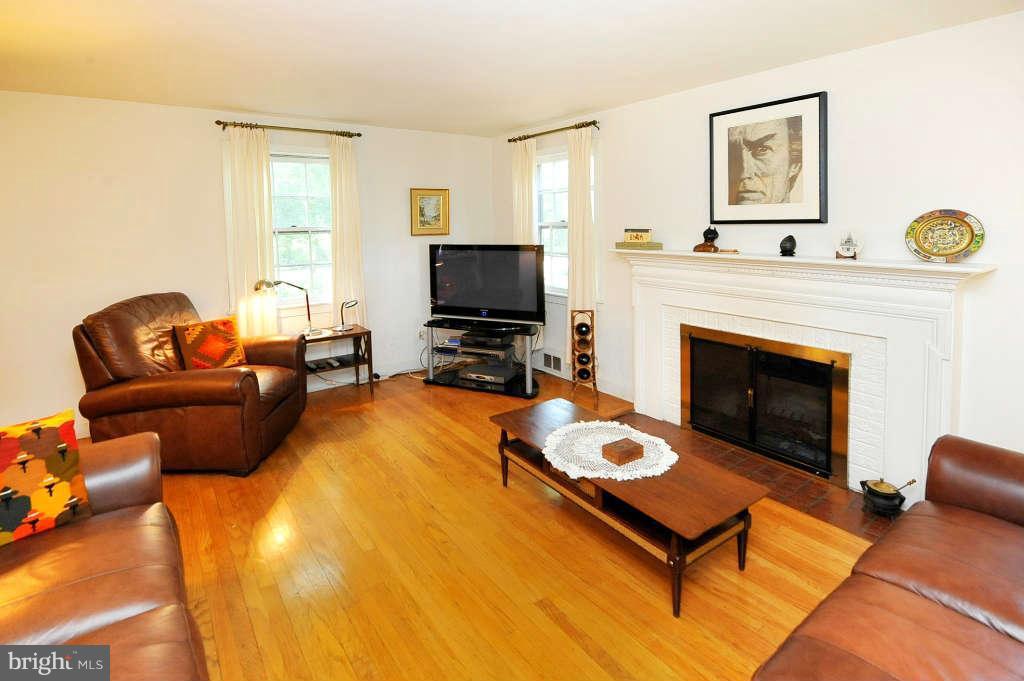 4523 Sleaford Road Bethesda, MD 20814 - Photo 5 of 23 a living room with furniture a flat screen tv and a fireplace