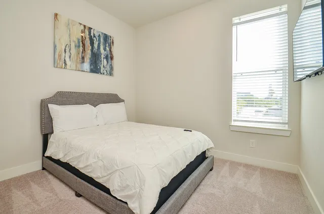 a large bed sitting in a bedroom next to a window