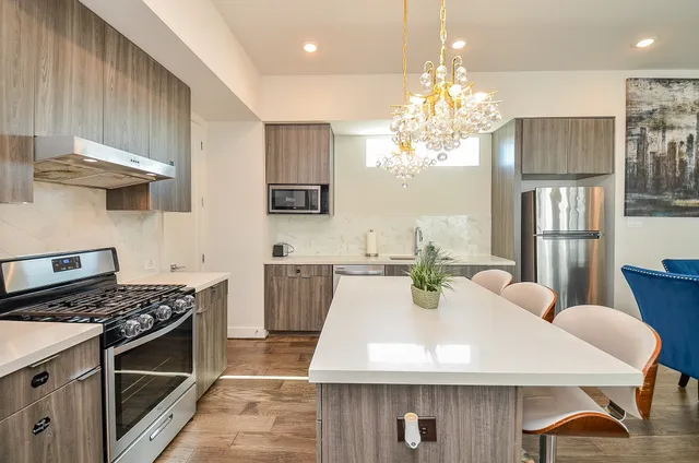 a kitchen with stainless steel appliances a table chairs and stove