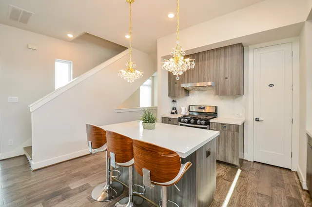 a kitchen with granite countertop a table chairs stove and wooden floor