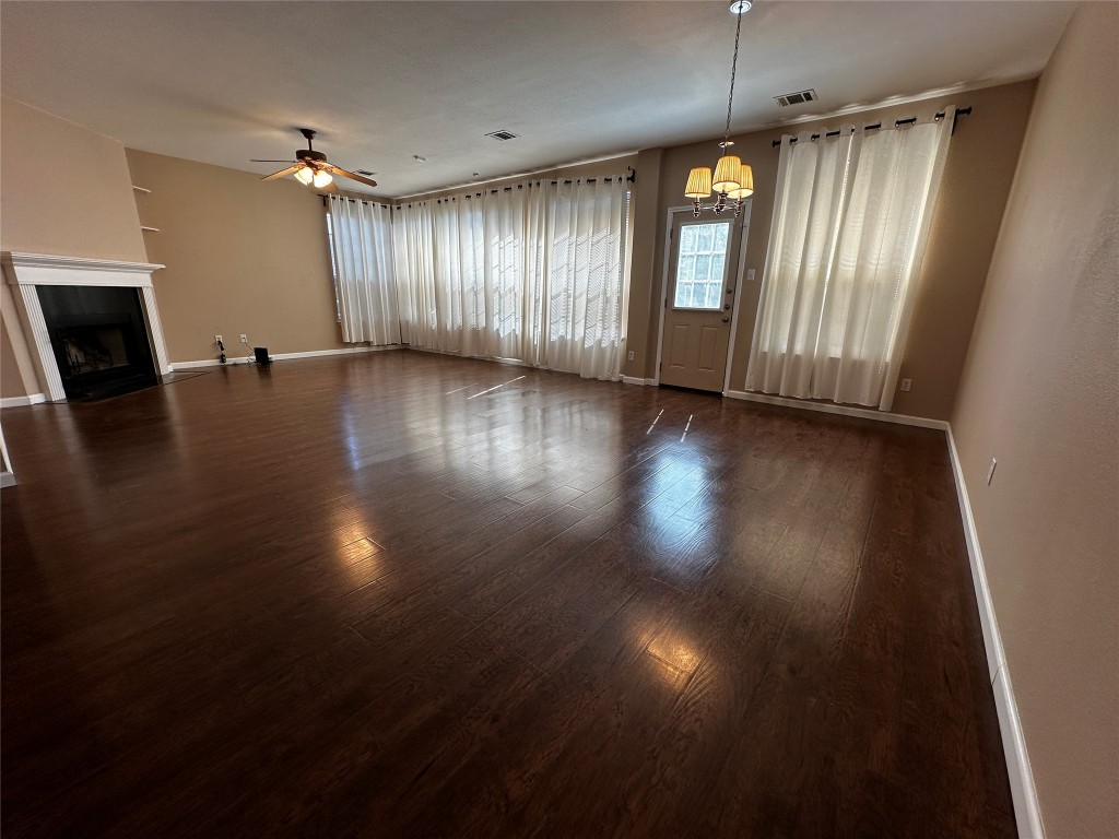 1041 Disraeli Circle Pflugerville, TX 78660 - Photo 12 of 29 an empty room with wooden floor and windows