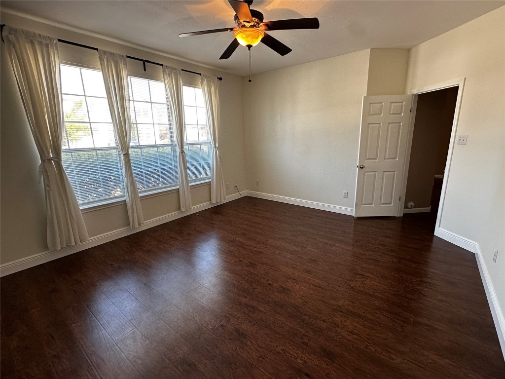 1041 Disraeli Circle Pflugerville, TX 78660 - Photo 14 of 29 an empty room with wooden floor fan and windows