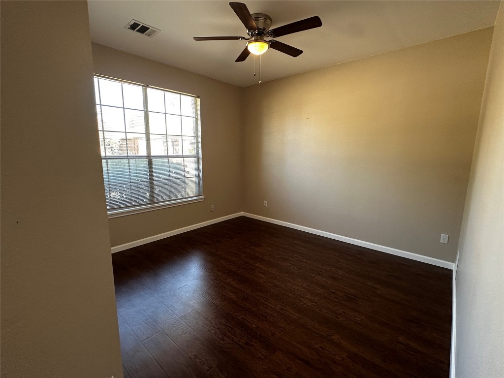 1041 Disraeli Circle Pflugerville, TX 78660 - Photo 25 of 29 an empty room with wooden floor fan and windows