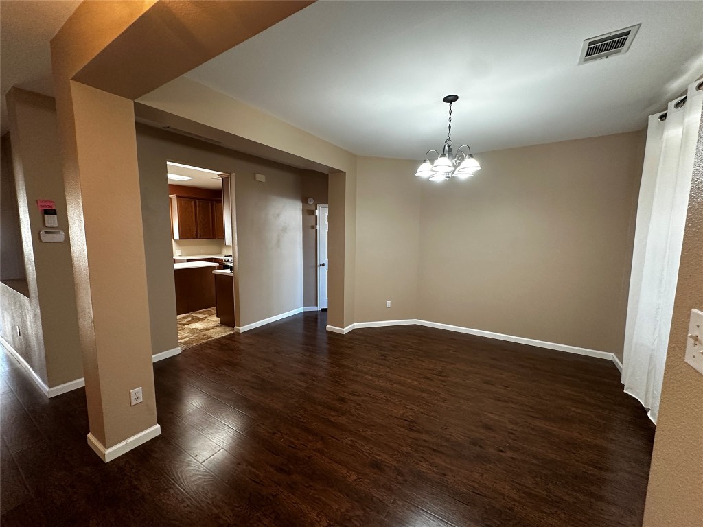 1041 Disraeli Circle Pflugerville, TX 78660 - Photo 7 of 29 an empty room with wooden floor chandelier and windows