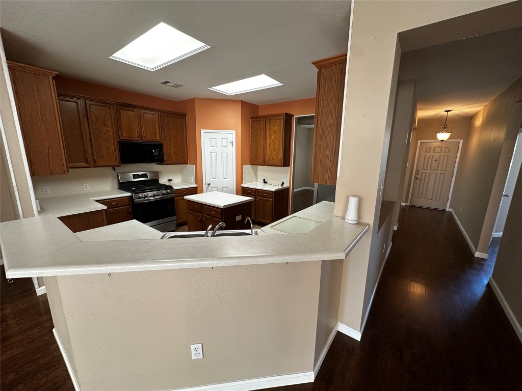 1041 Disraeli Circle Pflugerville, TX 78660 - Photo 9 of 29 a kitchen with a sink a stove and a refrigerator