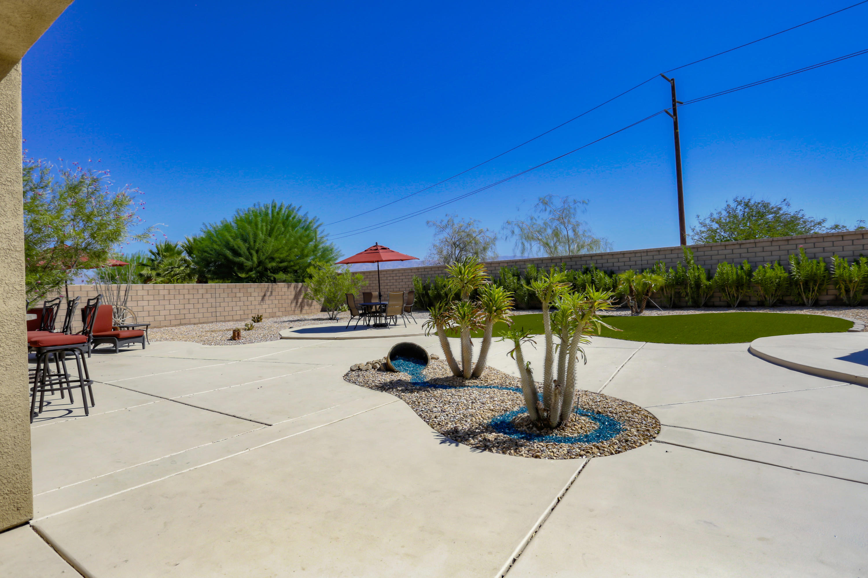 35880 Raphael Drive Palm Desert, CA 92211 - Photo 25 of 28 a view of a patio with a table and chairs under an umbrella