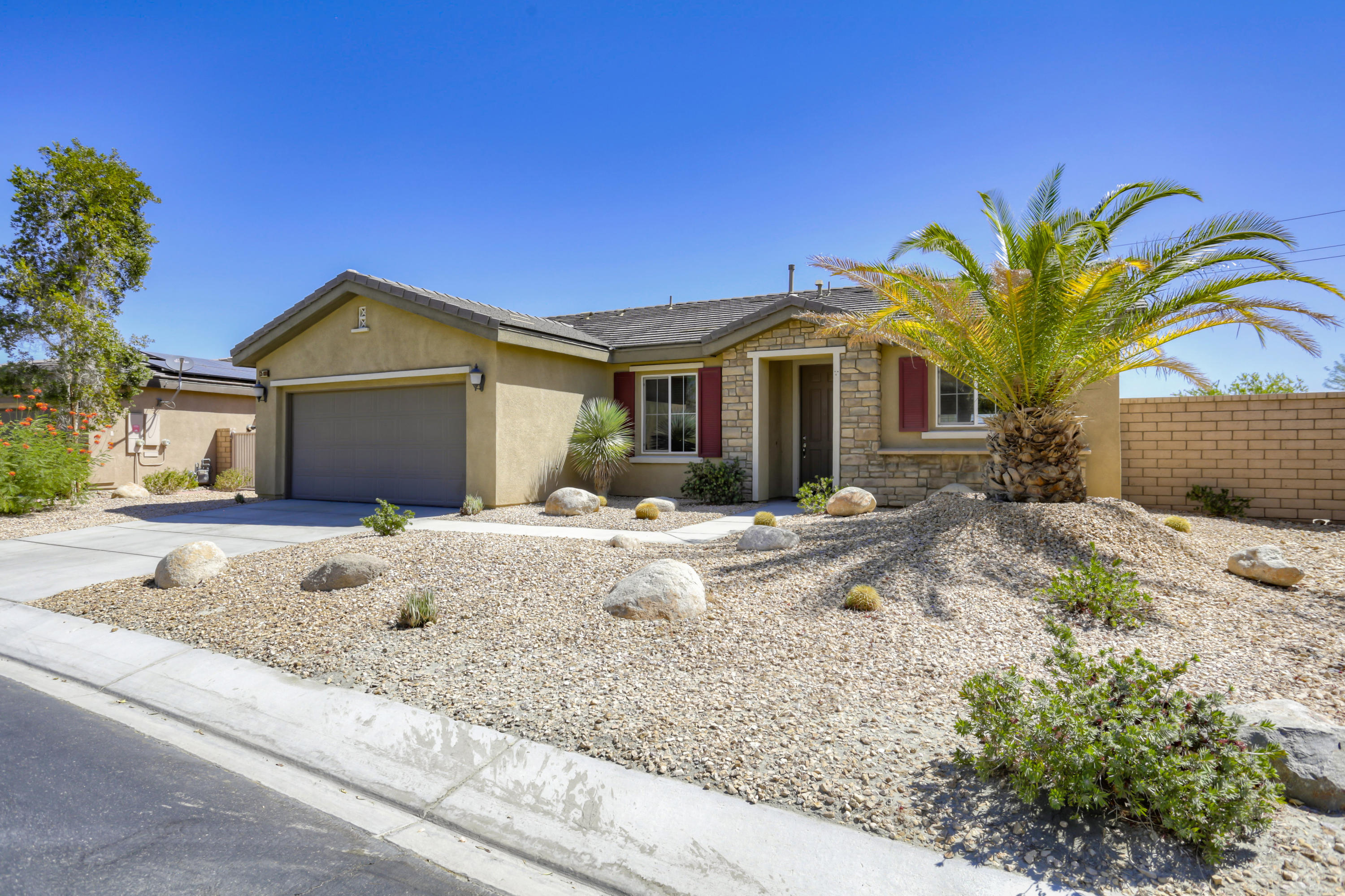35880 Raphael Drive Palm Desert, CA 92211 - Photo 3 of 28 a front view of a house with a yard and potted plants
